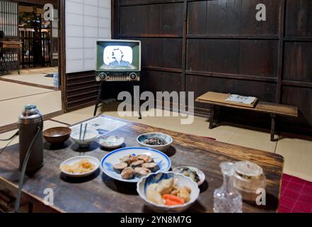 Wohneinrichtung aus der Showa-Zeit um 1950 bis 1960 mit Tatami-Mattenboden, Schiebetüren und niedrigem Esstisch mit Zabuton-Kissen. Stockfoto