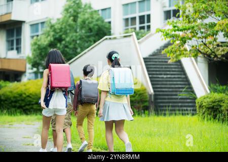 Grundschulen, Jungen und Mädchen, die Schulrucksäcke tragen Stockfoto