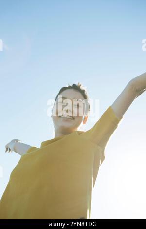 Eine Frau in ihren Zwanzigern, die einen Hail Mary unter blauem Himmel macht Stockfoto