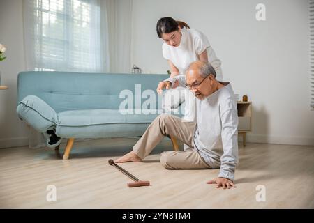 Eine junge Frau aus Asien, die ihren Vater schläft, nachdem sie auf den Boden gefallen ist Stockfoto