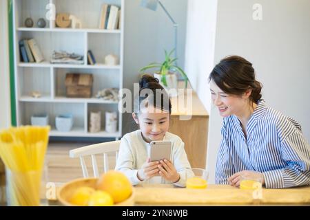 Mädchen, das ein Smartphone im Wohnzimmer bedient Stockfoto