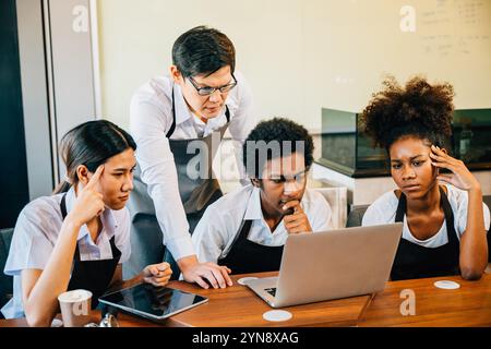 Der Coffee-Shop bringt jungen Unternehmern Freude und Spaß. Planung der Verwaltung mit einem Laptop Stockfoto