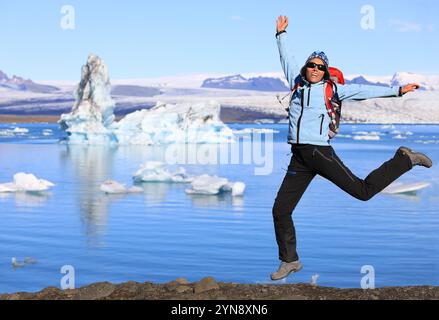 Mädchen in wasserdichter Kleidung hat Spaß beim Springen an der Küste des großen Gletschersees Jokulsarlon im Südosten Islands Stockfoto