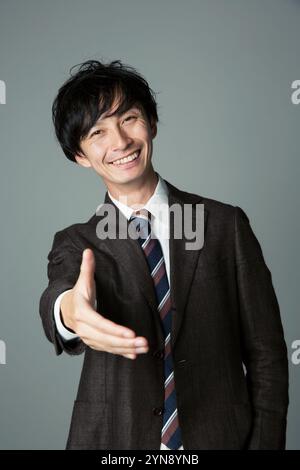 Ein lächelnder Mann bietet seine Hand an Stockfoto