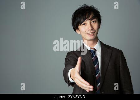 Ein lächelnder Mann bietet seine Hand an Stockfoto