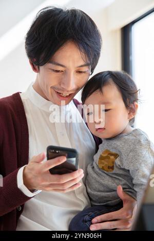 Mann zeigt dem Baby das Telefon Stockfoto