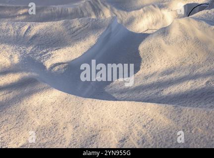 Abstraktes Schattenmuster auf einer Schneelage im Winter Stockfoto