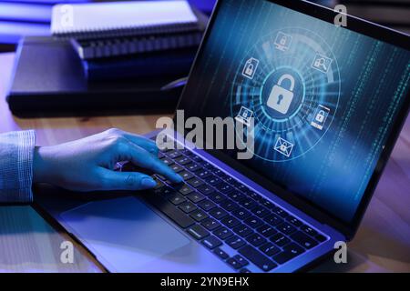 Cybersicherheit. Frau, die einen Laptop am Tisch in Neonlichtern benutzt, Nahaufnahme Stockfoto