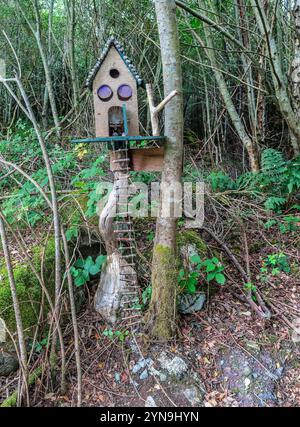 Ein bezauberndes rustikales Märchenhaus auf einem Baum mit einer Holzleiter, eingebettet in einen üppigen, magischen Wald. Ideal für Konzepte von Fantasie, Wimsy und na Stockfoto