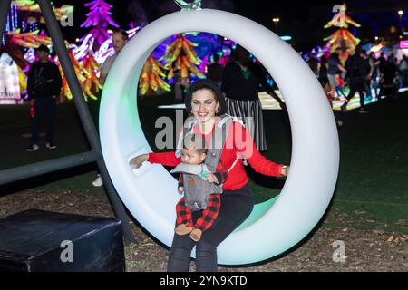 Dallas, USA. November 2024. Eine Mutter mit einem Baby sitzt auf einem leuchtenden Stuhl beim Tianyu Lights Festival in Dallas, Texas, USA, am 24. November 2024. Die Veranstaltung findet vom 8. November 2024 bis zum 18. Januar 2025 statt und bietet atemberaubende, leuchtende Kunstinstallationen und nächtliche Darbietungen von Akrobaten und Volkskünstlern aus China. Quelle: Dan Tian/Xinhua/Alamy Live News Stockfoto