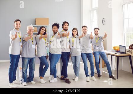 Glückliches Freiwilligenteam, Das Die Daumen Hoch Im Humanitären Hilfszentrum Gibt Stockfoto