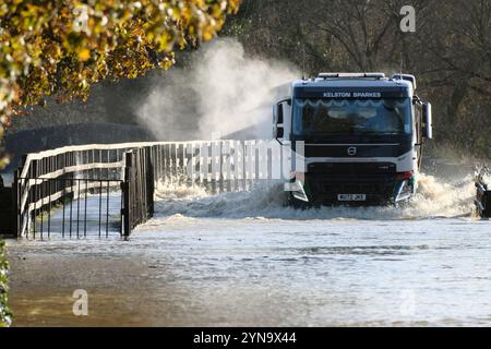 Lacock, Wiltshire, Großbritannien. November 2024. Der starke Regen des Sturms Bert hat den Fluss Avon in Lacock überschwemmt. Die Straße ist für alle bis auf die größten Fahrzeuge unpassierbar. Dieser Standort wird mehrmals im Jahr überschwemmt, aber heute ist das Wasser viel höher, und das Hochwasser erstreckt sich normalerweise nicht über den Damm hinaus, sondern hat es heute getan. Quelle: JMF News/Alamy Live News Stockfoto