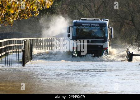 Lacock, Wiltshire, Großbritannien. November 2024. Der starke Regen des Sturms Bert hat den Fluss Avon in Lacock überschwemmt. Die Straße ist für alle bis auf die größten Fahrzeuge unpassierbar. Dieser Standort wird mehrmals im Jahr überschwemmt, aber heute ist das Wasser viel höher, und das Hochwasser erstreckt sich normalerweise nicht über den Damm hinaus, sondern hat es heute getan. Quelle: JMF News/Alamy Live News Stockfoto