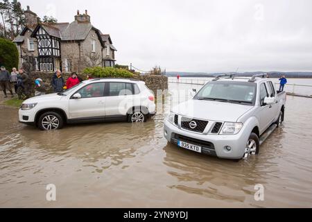 Autos auf der Straße während der Überschwemmung in Storth an der Mündung des Kent River Stockfoto