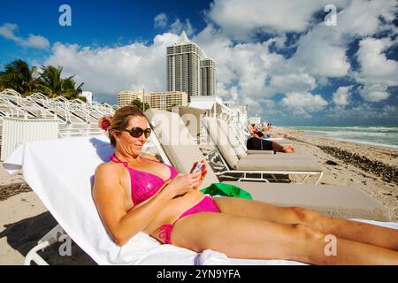 Frau, die sich am Miami Beach sonnt Stockfoto