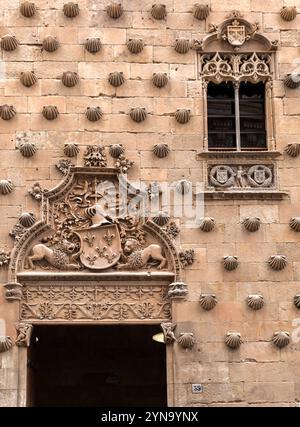 Ein detaillierter Blick auf ein historisches Steingebäude in Salamanca mit dekorativem Fenster mit aufwändigen Eisenarbeiten. Stockfoto