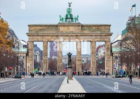 Brandenburger Tor, Berlin, 22.11.2024 das Bild zeigt das Brandenburger Tor in Berlin in einer frontalen Ansicht. Im Hintergrund ist das Rote Rathaus sichtbar, während im Vordergrund der Platz fast leer wirkt, mit wenigen Menschen und Radfahrern auf der Straße. Die leichten Herbstfarben der Umgebung verleihen der Szene eine ruhige Atmosphäre, Berlin Deutschland *** Brandenburger Tor, Berlin, 22 11 2024 das Bild zeigt das Brandenburger Tor in Berlin in einer Frontalansicht das Rote Rathaus ist im Hintergrund sichtbar, während im Vordergrund der Platz fast leer aussieht, mit wenigen Personen A Stockfoto