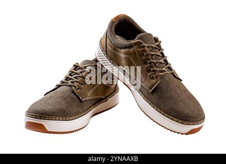 Ein Paar khakifarbene Sneakers aus Canvas. Neue braune Textilschuhe mit weißen Sohlen auf weißem Hintergrund. Bequeme Sneakers. Stockfoto