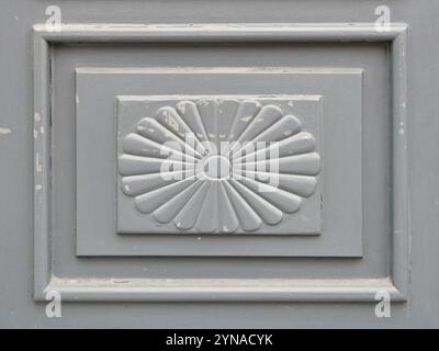 Türblatt - Rosette - grau - komplizierte Holzrosette an einer alten, grauen Holztür. Die Patina und Schnitzereien erzählen Geschichten aus der Vergangenheit. Stockfoto