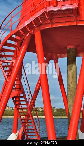 South Shields neu restaurierter, antiker Leuchtturm von Herd Sands mit Tynemouth im Hintergrund vor einem blauen Himmel Stockfoto