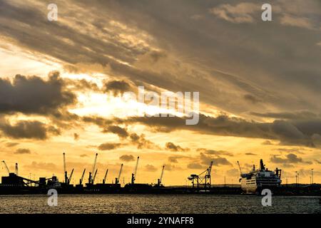 DFDS-Nordsee-Fähren laden und Werftkrane auf dem Fluss Tyne bei einem goldenen Sonnenuntergang Stockfoto