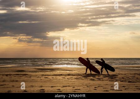 Frankreich, Charente-Maritime, Côte Sauvage, Pointe de la Coubre, La Tremblade, Vieux Phare Beach, Surfer am Vieux Phare Beach bei Sonnenuntergang Stockfoto