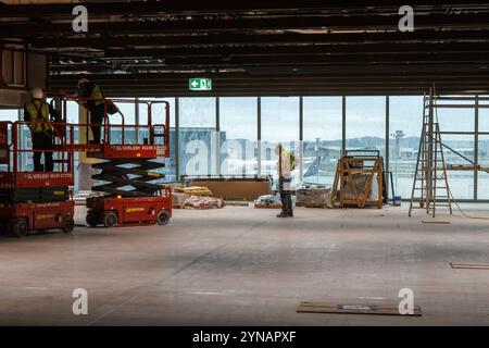 25. November 2024, Hessen, Frankfurt/M.: Bauarbeiter arbeiten auf Hebebühnen. Terminal 3 soll 2026 eröffnet werden. Foto: Lando Hass/dpa Stockfoto