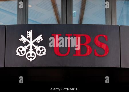 Schild und Logo am Eingang einer UBS-Filiale in Genf, Schweiz. Die UBS Group AG ist eine schweizerische internationale Bankengruppe Stockfoto