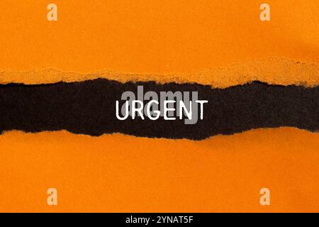 Dringende Nachricht auf gerissenem, gerissenem orangefarbenem Papier mit schwarzem Hintergrund. Konzeptionelles dringendes Wortsymbol. Kopierbereich. Stockfoto