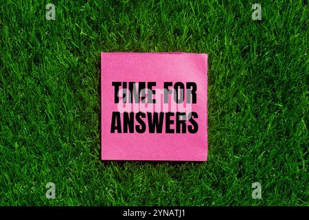 Zeit für Antworten Nachricht geschrieben auf gerissenem rosafarbenem Papier mit grünem Grashintergrund. Symbol für die konzeptionelle Zeit für Antworten. Kopierbereich. Stockfoto