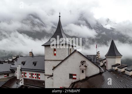 WERFEN, ÖSTERREICH - 20. MAI 2019: Das sind die Türme der Burg Hohenwerfen vor der Kulisse von Bergen und Nebel an einem regnerischen Frühlingstag. Stockfoto