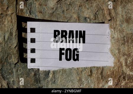 Hirnnebelbotschaft geschrieben auf zerrissenem Papierstück mit Steinhintergrund. Konzeptionelles Hirnnebelsymbol. Kopierbereich. Stockfoto