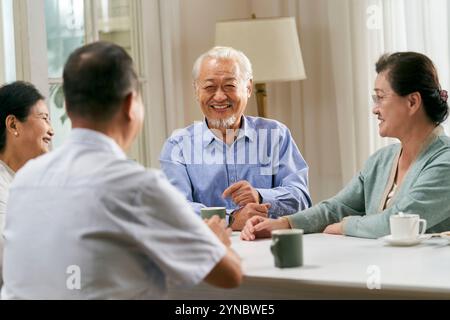 Gruppe glücklicher asiatischer Senioren, zwei Paare, die sich zu Hause treffen und unterhalten Stockfoto