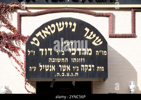 Ein jiddisch-hebräisches Schild und ein Baldachin am Eingang einer Synagoge, der einem großen Spender dankt. In Williamsburg, Brooklyn, New York. Stockfoto