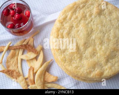 Blick von oben über einen Haufen gebackener dünner, runder Butterschichten, Teigreste auf einem weißen Waffeltuch, bereit für einen kurzen Blätterteig Napoleon Kuchen. Stockfoto