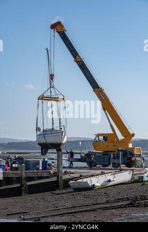 Mobile Krane heben Yachten und Boote für die Wintersaison an Land auf einer Bootswerft in Keyhaven, Hampshire, Großbritannien Stockfoto