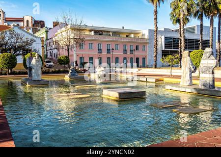 Praca Al Mutamid Platz mit Springbrunnen und modernen Skulpturen in Silves, Portugal. Statuen männlicher Steinmönche in einem Zierbecken in Praca Al-Mutami Stockfoto