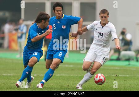 TIANJIN, CHINA - 7. AUGUST: Robbie Rogers aus den Vereinigten Staaten (14) greift auf Takuya Honda (16) und Keisuke Honda (8) aus Japan während eines Gruppenspiels beim Fußballturnier der Olympischen Spiele in Peking am 7. August 2008 im Tianjin Olympic Sports Center Stadium in Tianjin, China an. Nur redaktionelle Verwendung. (Foto: Jonathan Paul Larsen / Diadem Images) Stockfoto