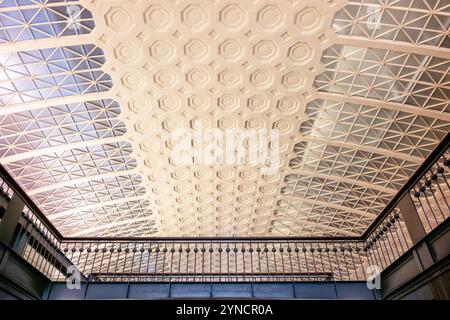 Union Station Decke und Geländer Washington DC // WASHINGTON DC – die kunstvolle Decke und das dekorative Metallgeländer über der Haupthalle der Union Station zeigen den Beaux-Arts-Stil des Gebäudes. Der vom Architekten Daniel Burnham entworfene und 1908 fertiggestellte Bahnhof verfügt über aufwändige Deckendetails mit Kassettenpaneelen und vergoldeten Akzenten. Die schmiedeeisernen Geländer im Zwischengeschoss bieten sowohl funktionale Sicherheit als auch dekorative Elemente, die der klassischen Designsprache des Gebäudes entsprechen. Stockfoto