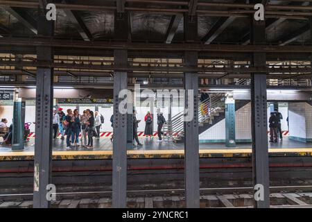 New York, New York, USA – 30. Oktober 2024: Pendler warten auf einem U-Bahnsteig am New York, New York, USA. Stockfoto