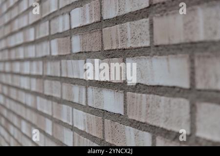 Beige und graue Backsteinwand Hintergrund Nahaufnahme. Grauer Steinfliesenblockhintergrund mit horizontaler Textur des grauen Ziegels. Graue Ziegeloberfläche Stockfoto