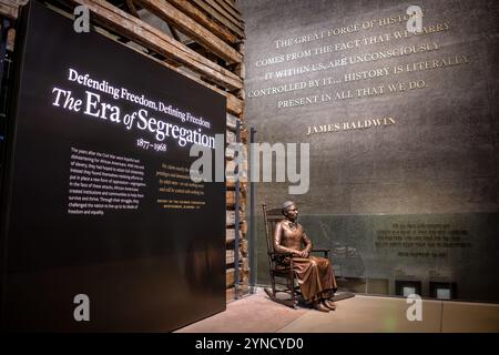 National Museum of African American History Clara Brown Statue Washington DC // WASHINGTON DC – Eine Bronzestatue von Clara Brown, bekannt als „Tante Clara“, markiert den Eingang zum National Museum of African American History and Culture, der Ausstellung zur Ära der Segregation. Die sitzende Figur erinnert an Browns Rolle als bahnbrechende afroamerikanische Geschäftsfrau im Colorado-Territorium nach ihrer Emanzipation. Die Statue stellt die Ausstellung des Museums über das afroamerikanische Leben von 1877 bis 1968 vor. Stockfoto
