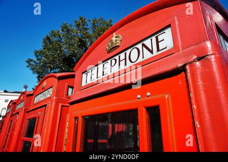 Roter Telefonkasten London Vereinigtes Königreich | LONDON, Vereinigtes Königreich — Ein klassischer roter Telefonkasten steht auf einer Londoner Straße, ein ikonisches Symbol britischen Erbes und urbanen Designs. Entworfen von Sir Giles Gilbert Scott in den 1920er Jahren, wurden diese markanten K6-Kioske mit ihrer leuchtend roten Farbe und der Kroneninsignie im gesamten 20. Jahrhundert zum Inbegriff britischer Straßenbilder. Obwohl sie in der Ära der Mobiltelefone weitgehend veraltet sind, wurden viele dieser historischen Kabinen als geschützte Denkmäler erhalten oder für alternative Nutzungen im gesamten Vereinigten Königreich umgenutzt. Stockfoto