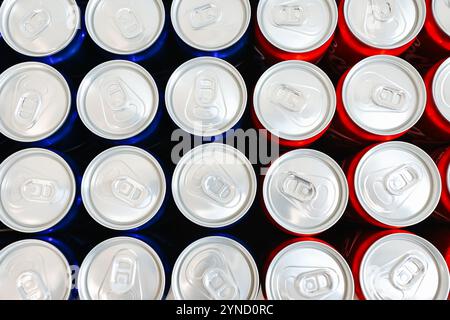 Blick von oben auf die ordentlich angeordneten roten und blauen Getränkedosen mit silbernen Platten, die Einfachheit, Erfrischung und modernes Design symbolisieren. Ideal für Themen Stockfoto