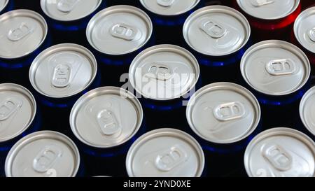 Blick von oben auf die ordentlich angeordneten roten und blauen Getränkedosen mit silbernen Platten, die Einfachheit, Erfrischung und modernes Design symbolisieren. Ideal für Themen Stockfoto