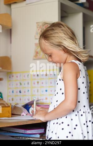 Inspiration. Ein Vorschulmädchen konzentriert sich auf das Zeichnen mit einem Filzstift, Eine junge Künstlerin verliert sich in einer Welt ihrer eigenen Schöpfung Stockfoto