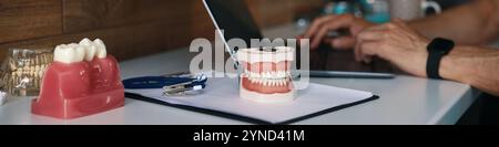 Tippen auf Laptops in der Nähe von Zahnersatz und Werkzeugen Stockfoto