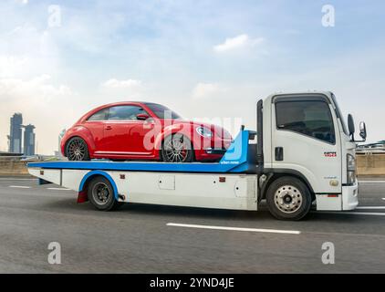 BANGKOK, THAILAND, 09. November 2024, Ein Lkw mit Plattform transportiert einen volkswagen-Käfer Stockfoto