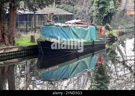 Ein Boot, das auf dem schönen Basingstoke Canal in Surrey vor Anker liegt Stockfoto