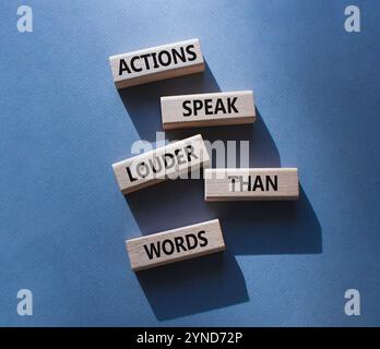 Taten sprechen lauter als Wörter. Holzblöcke mit Worten Aktionen sprechen lauter als Worte. Schöner grauer Hintergrund. Business and Actions conc Stockfoto
